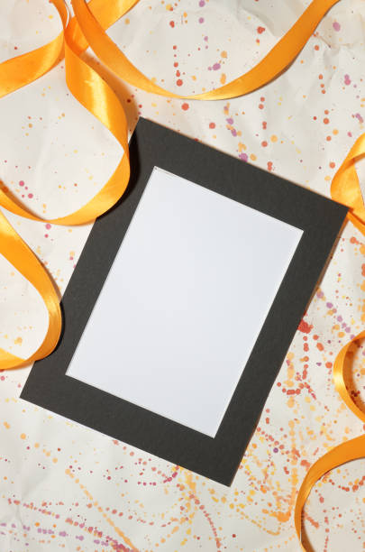 istock Black blank picture frame with ribbons and tubes with paints 1150941135