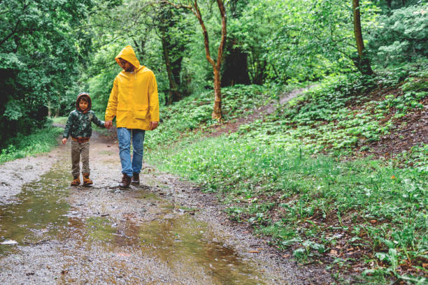 istock Father and son walking in the rain 1150943240