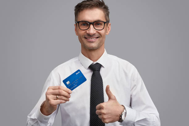 istock Businessman with plastic card gesturing thumb up 1150944453