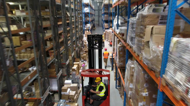 istock Warehouse logistic center. Worker driving on a forklift. Aerial view 1150944819