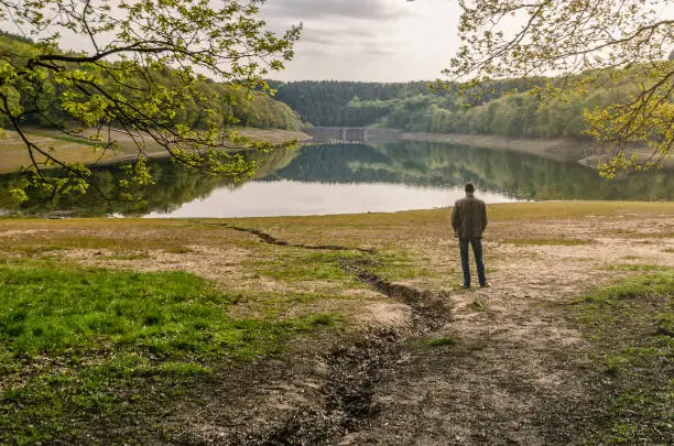Photo of lonely man on the background of nature stands and admires