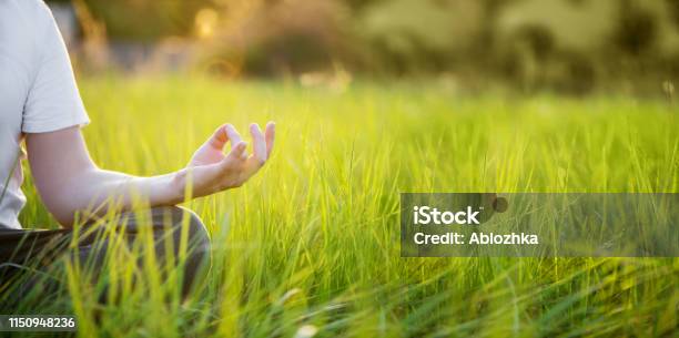 Man Is Meditating On Green Grass In The Park On Sunny Summer Day Concept Of Meditation And Healthy Lifestyle Stock Photo - Download Image Now
