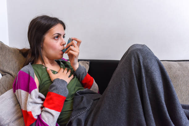 istock Young woman using an asthma inhaler 1150949139