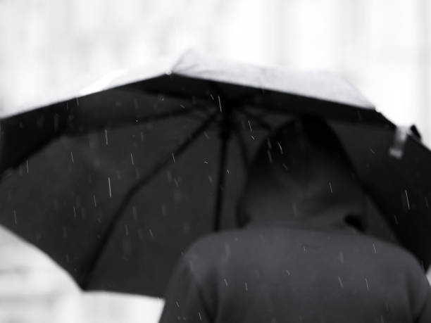 homme en noir sous un parapluie noir sous la pluie. focus sur les gouttes de pluie - sweat women wet shirt photos et images de collection