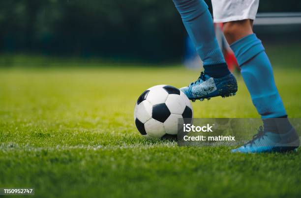 Close Up Of Legs And Feet Of Football Player In Blue Socks And Shoes Running And Dribbling With The Ball Soccer Player Running After The Ball Sports Venue In The Background Stock Photo - Download Image Now