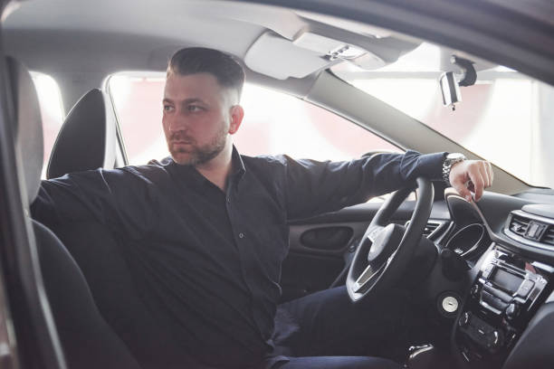 istock Going back. Side view of man sitting in the modern car with black interior 1150955762