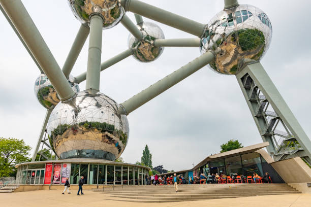 Brussels, Belgium - May 19 2019: People walk and visit the ticket office and cafe at the base of the Atomium building in Brussels.