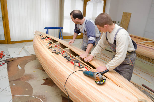 istock Carpenters making wooden canoe in the workshop 1150957381