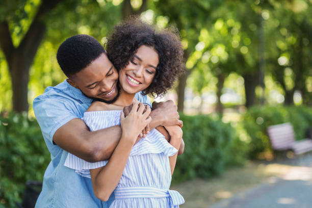 istock Happy couple embracing in park on sunny day 1150964355