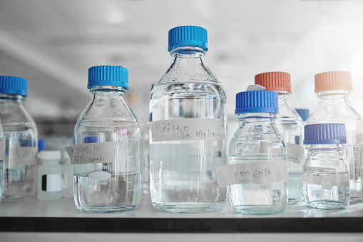 Shot of labeled bottles with liquid in them in a modern laboratory