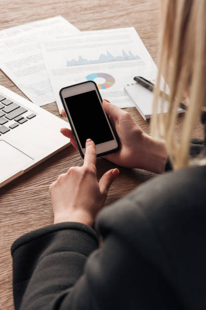 istock Partial view of woman holding smartphone with blank screen 1150965112