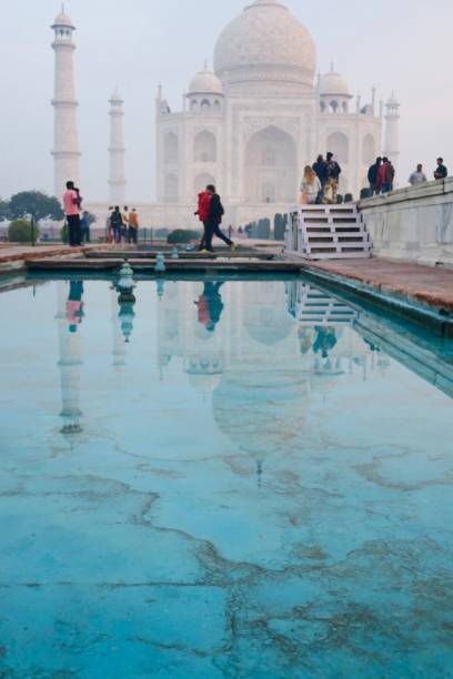 image des réflexions de piscine de lotus bleu à l’heure dorée de marbre blanc de l’architecture taj mahal, minarets et dômes d’oignon, les touristes tôt le matin du lever du soleil et les visiteurs en vacances dans la ville d’agra, uttar prade - agra architecture asia city of sunrise photos et images de collection