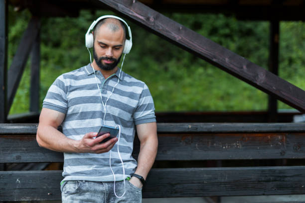 istock Man listening music on smart phone. Copy space. 1150968504
