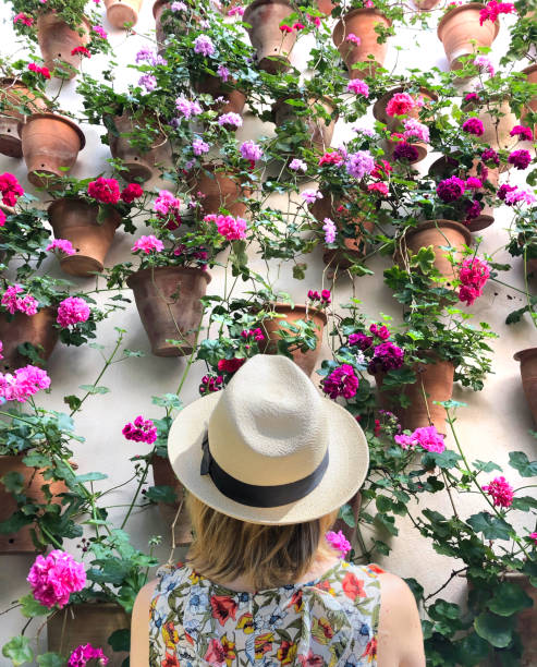 스페인 코르도바에서 꽃을 감상 하는 여자 - ornamental garden multi colored white pink 뉴스 사진 이미지