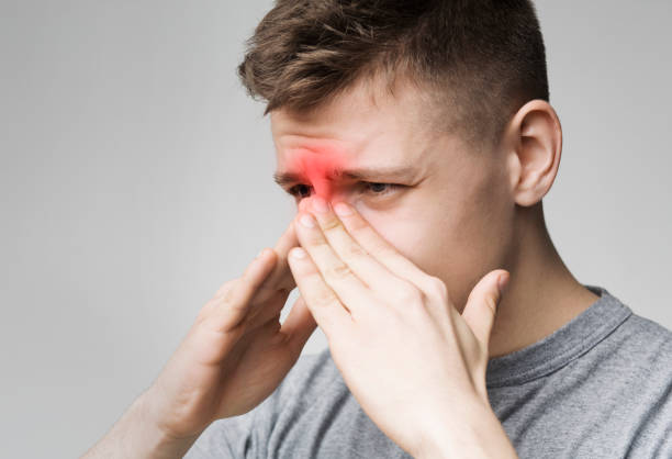 istock Sad man holding his nose because sinus pain 1150970084