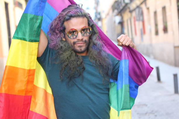 istock Trendy man raising the rainbow flag 1150973361