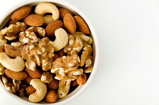 mix of nuts in a cocotte on a white background.