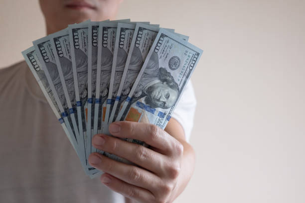 istock Asian man holding one hundred dollar bill. Wealthy and richness concept. 1150975183