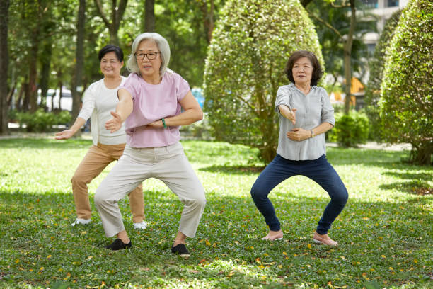 istock Senior instructor exercising with females in park 1150977952