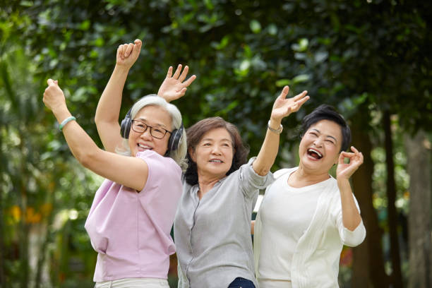 istock Friends with arms raised dancing in park 1150978028