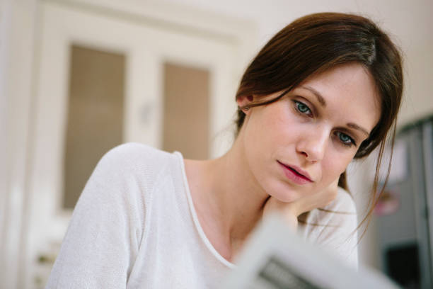 istock young woman reads the newspaper while breakfast in the kitchen 1150979148