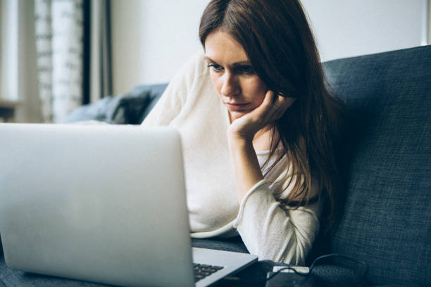 istock young woman sit on sofa and use laptop at home 1150979173