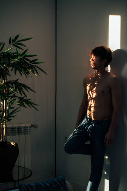 istock Man standing near plant with shadow light 1150979543