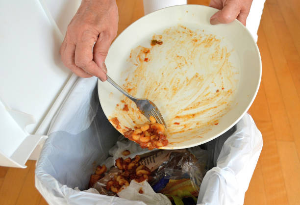 Lifestyle... This close up shot shows, still edible food, being thrown into a garbage bin.