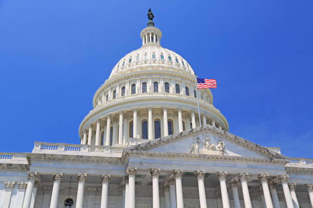 istock National Capitol building with US flag in Washington DC 1150983347