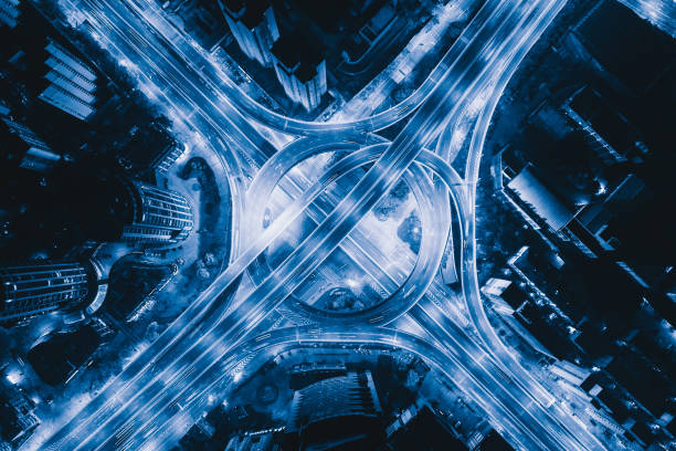 Aerial view of highway junctions with roundabout. Bridge roads shape circle in structure of architecture and transportation concept. Top view. Urban city, Shanghai at night, China.