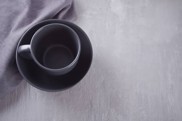 istock Empty black bowl and mug on the gray table. 1150988077