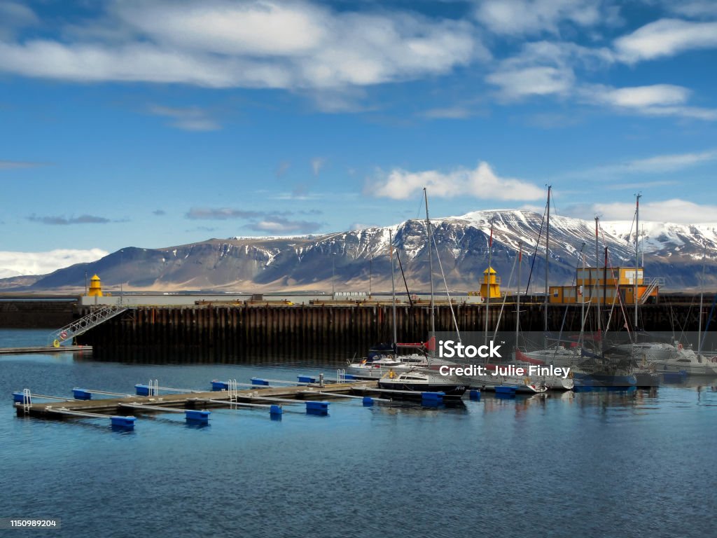 Fishing Boats at Faxa Bay Harbor, in Reykjavik Iceland Fishing Boats docked at Faxa Bay Harbor, in Reykjavik Iceland, taken in late May, 2016.  Dock, water, sky, and mountains are in view. Bay of Water Stock Photo