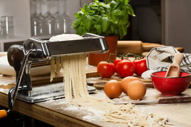 Photo of Pasta machine with noodles and ingredients