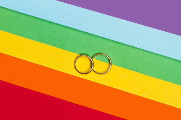 istock Two gold rings on a gay pride flag 1150996288
