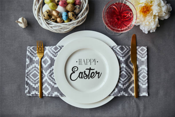 istock top view of festive table setting for Easter with decor, painted eggs and happy Easter lettering on plate 1150998658