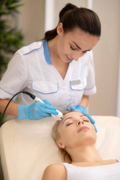 istock Dark-haired dermatologist doing face lifting for woman 1150999254