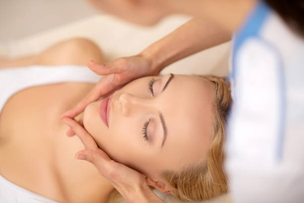 istock Woman closing her eyes while enjoying face massage 1150999340
