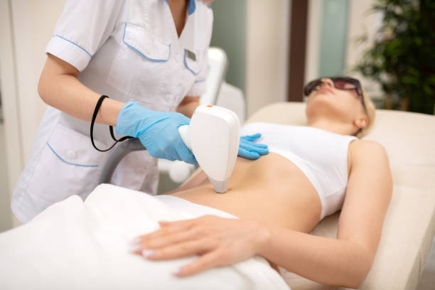 istock Depilatory master making laser depilation around navel of client 1151000489