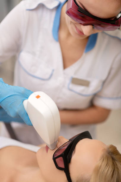 istock Depilatory master in protective glasses doing laser depilation 1151000500