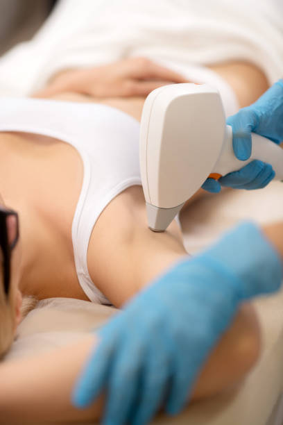Depilatory specialist making laser depilation under arms