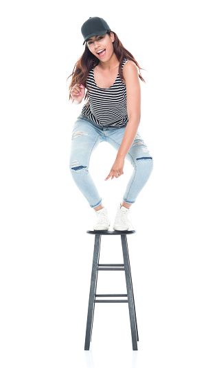 Latino young adult woman wearing tank top and torn jeans