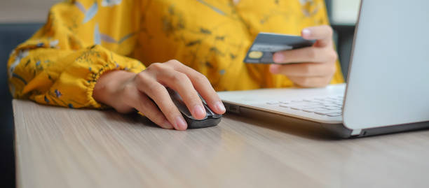Asian woman holding credit card and using laptop for online shopping while making orders. internet, technology, ecommerce and online payment concept Asian woman holding credit card and using laptop for online shopping while making orders. internet, technology, ecommerce and online payment concept credit card paying banking business stock pictures, royalty-free photos & images