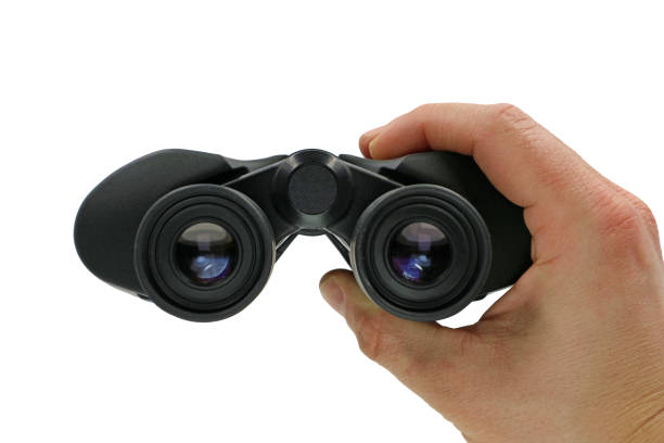 z bliska, widok z przodu dłoni trzymającej czarną lornetkę na białym tle - focus binoculars spy eyesight zdjęcia i obrazy z banku zdjęć