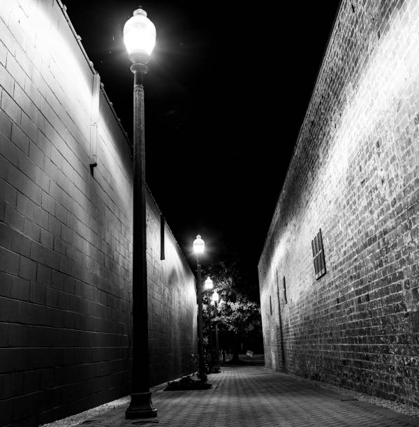 istock BW alley with lamps after dark 1151011704