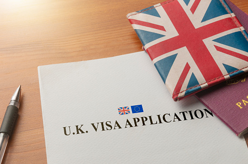 Visa application on desktop with passport and union jack wallet