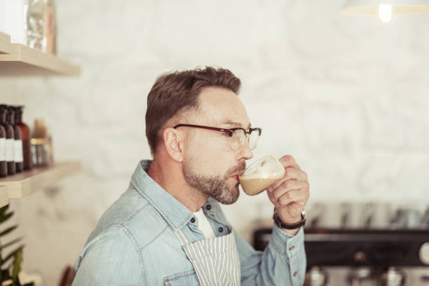 istock Handsome man drinking his cappuccino and smiling. 1151012630