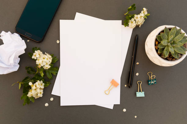 istock Work desk, table mock up with smartphone, blank pappers, spring flowers frame. Office work table. Copy space. 1151019532