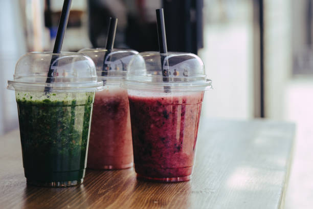 istock Sweet smoothie in plastic cups on wooden table 1151024624