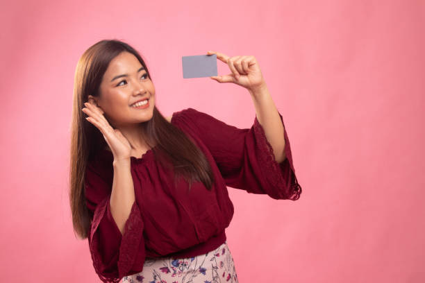 istock Young Asian woman happy with  blank card. 1151031413