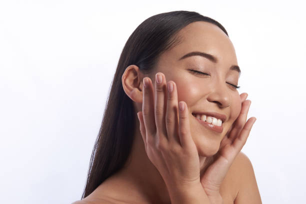 istock Pleased young woman smiling and touching her cheeks 1151033156